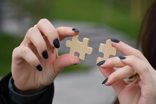 One person with two pieces of a puzzle