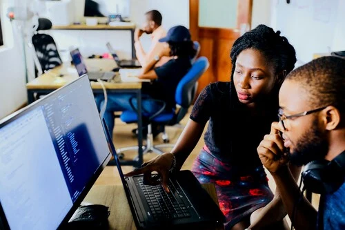 Two people in front of computer screens